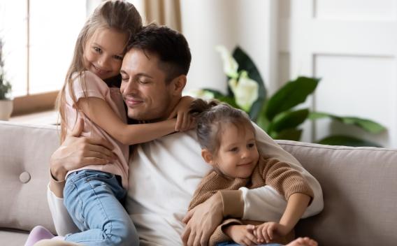 Father embracing daughters
